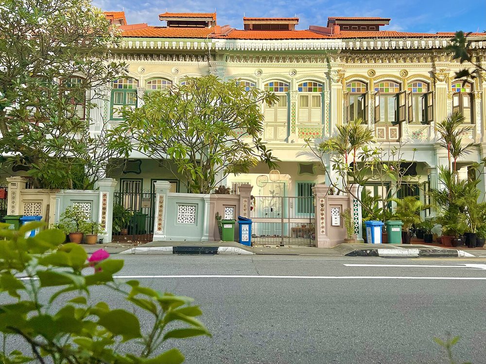 Cream and pastel Peranakan terrace houses with ornate facades and front gardens on Koon Seng Road, Singapore